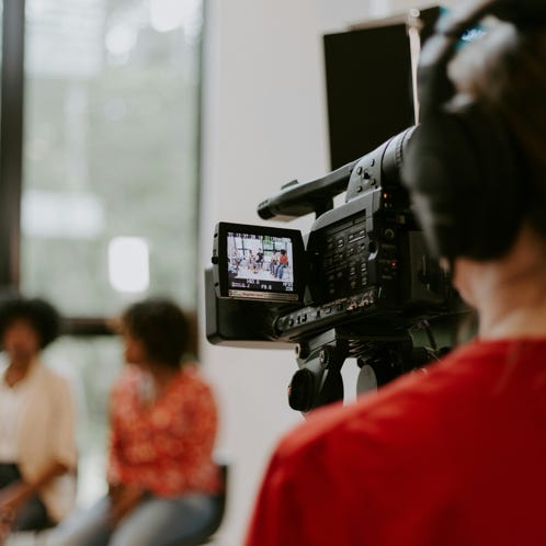 Group of police officers in uniform patrolling a crowded city street on a sunny day.